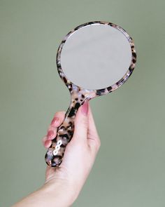 • 1 cellulose acetate hand mirror • Mirror is standard 1x reflection, 4.25” diameter • White logo on inside handle • 4.75” x 9.5”, 7mm thickness • Cellulose acetate is a natural, biodegradable bioplastic made mostly from wood pulp. Durable, flexible and anti-static, with natural variation in color and pattern. Hand Held Mirror, Women's Hair Accessories, Rock Hand, Vintage Packaging, Cellulose Acetate, Hand Mirror, River Rock, Women's Hair, Mirror Mirror