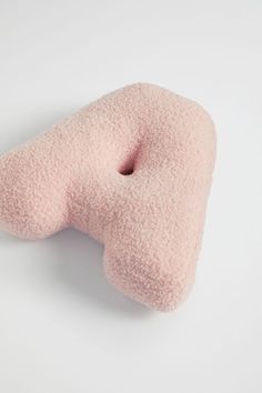 a pink donut shaped pillow sitting on top of a white table