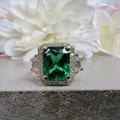 an emerald colored stone surrounded by white and yellow diamonds