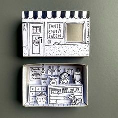 two small boxes with drawings on them sitting next to each other, one has a window and the other has a door