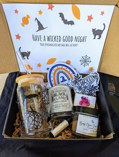 an open box with various items in it that include cookies, jams and candles