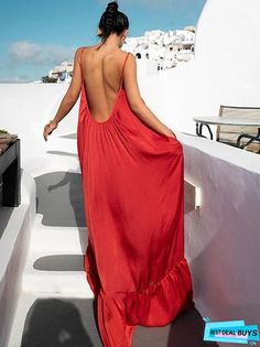 a woman in a red dress is walking up the stairs to an outdoor area with white walls