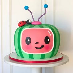 there is a cake that looks like a tv set with ladybugs on it