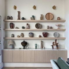 a living room filled with lots of shelves and vases on top of each shelf