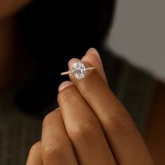 a woman's hand holding a diamond ring