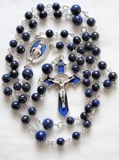 This lapis lazuli rosary can also be worn as a necklace. The body is about 27 inches and the cross extension is 6 inches. The blue enameled cross and connection were made in Italy and are oxidized silver. I used 6mm and 8mm lapis rounds and hand turned each of the wires myself. The crucifix is 1 and 3/4 inches long. This rosary will be slipped into an organza bag and shipped in a bubble mailer. Blue Crucifix Necklace For Spiritual Wear, Blue Crucifix Necklace For Spiritual Purposes, Blue Rosary With 8mm Beads And Crucifix, Blue Rosary With 8mm Beads In Cross Shape, Blue Rosary With 8mm Beads For Healing, Blue Spiritual Rosary With Gemstone Beads, Blue Gemstone Beads Rosary For Spiritual Use, Spiritual Blue Rosary With Gemstone Beads, Blue Cross Rosary As Gift