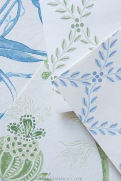 some blue and green flowers on white paper