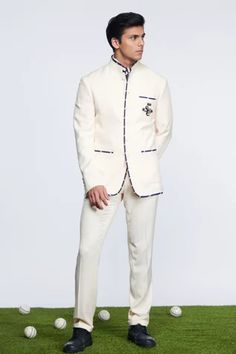 Off white bandhgala in suiting fabric base featuring SNCC patch logo along with contrasting stripe piping.
Component: 1
Pattern: Embroidered
Type Of Work: Patch Logo
Neckline: Band Collar
Sleeve Type: Full
Fabric: Suiting fabric
Color: Off White
Other Details: 
Front shank buttons
Contrasts striped piping
Note: Inner shirt, tie and pant worn by the model is not for sale
Occasion: Reception - Aza Fashions White Bandhgala, Bandhgala For Men, Straight Fit Pants, Suiting Fabric, Shirt Tie, Suit Fabric, Fabric Patch, Band Collar, Wool Pants