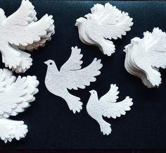 several white carved birds on a black surface