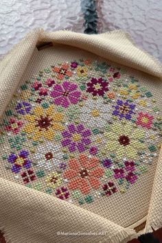 a close up of a piece of cloth on a table with a cross stitch pattern