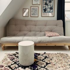 a living room with a couch, rug and pictures on the wall