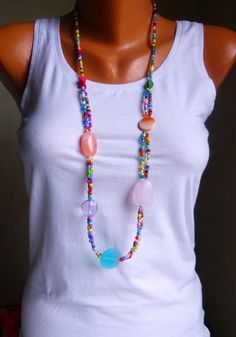 Colorful medium length necklace, 92 cm long. Colorful small glass beads (seed beads, rocailles, 4 mm), in between larger beads in turquoise, pink, lilac, apricot, orange made of acrylic, seashell, howlite (semi-precious stone). The flat round bead in turquoise at the bottom of the necklace has a diameter of 25 mm. Turquoise Beaded Hippie Necklace, Turquoise Hippie Beaded Necklace, Summer Multi-strand Colorful Beaded Necklaces, Spiritual Multi-strand Beaded Necklaces For Beach, Multicolor Multi-strand Bohemian Necklace, Pink Beaded Necklace For Beach With Colorful Beads, Summer Multicolor Faceted Beaded Necklaces, Multicolor Large Beaded Necklaces For Vacation, Long Beaded Necklaces For Beach