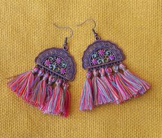 "Dangly treats for your ears featuring curtains of multicolored tassels swinging from gorgeous filigree fan-shaped pendants with hand-painted pink flower accents! Just pop them in your ears to add feminine, flirty, floral style to any outfit! And you can wear them happily because they are lightweight and super comfy, so no annoying pulling on your ears as they sway! Add these fun and fabulous Boho beauties to your jewelry box! Antiqued Copper-plated Earrings Earwires, Antiqued Copper-plated Pend Bohemian Tassel Earrings With Fringe For Spring, Pink Bohemian Earrings For Spring, Bohemian Pink Earrings For Spring, Multicolor Tassel Earrings For Festival, Bohemian Tassel Earrings With Latkans For Festivals, Spring Bohemian Tassel Earrings, Bohemian Dangle Tassel Earrings For Spring, Multicolor Bohemian Tassel Earrings, Bohemian Pink Earrings With Latkans