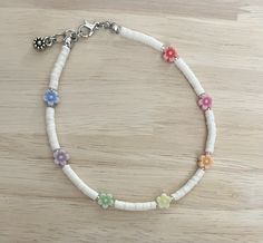 "Add that extra pop to any outfit this summer with this colorful daisyand white anklet! The anklet is made with an white polymer beads, colorful daisy beads and finished with a charm of your choice! Colors and size may vary from image. The anklet is available in a variety of sizes, just message me for custom sizes or an adjusted extender length! There is a size for everyone! :)  * All anklet sizes selected from the drop down menu are the size of the anklet without the 1/4\" chain extender. When Adjustable White Anklets For Spring, White Bohemian Bracelets For Spring, White Bohemian Bracelet For Spring, Adjustable White Anklets With Colorful Beads, White Beaded Anklets With Round Beads, White Round Bead Anklets For Summer, White Round Beads Anklet For Summer, White Anklets For Summer Festivals, Casual Colorful Beads Anklets For Spring