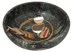 a marble bowl with two gold rings on the bottom and one silver ring in the middle