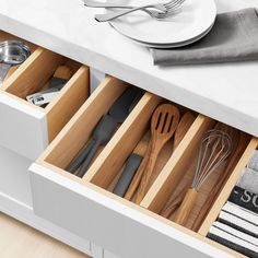 an open drawer with utensils in it