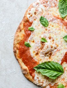 a pizza topped with cheese and basil leaves