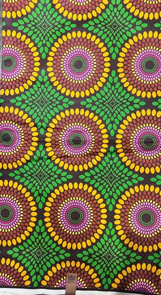 an artistically designed piece of cloth with circles and dots on black, green, orange, yellow and pink colors