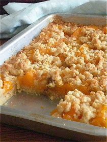 an orange dessert with crumbs in a pan