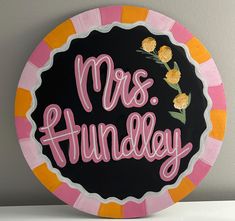 a black and pink plate with the words mrs hundley painted on it