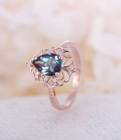 a close up of a ring with a blue stone in it on a white surface