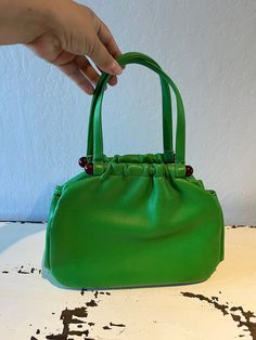 "Circa: 1950s 1960s Shamrock Green faux leather pouch handbag will be a sign of boldness. Beautiful rich green bag will hold more than you think with separate compartments. Tortoise lucite plastic bars and a simple snap closure, and that is very secure. Interior is black fabric.  DO YOU ACCEPT OFFERS? We do NOT accept offers or negotiate on pricing. We do offer layaways and have sales throughout the year. Shipping overages are always refunded. Label: Empress Fabric:  rayon interior, lucite plast Retro Green Shoulder Satchel, Retro Green Shoulder Bag Satchel, Retro Green Leather Satchel, Retro Green Shoulder Bag With Detachable Handle, Vintage Green Shoulder Bag For Shopping, Vintage Green Bags For Errands, Green Vintage Top Handle Satchel, Vintage Green Shoulder Bag For Errands, Retro Green Bags For Errands