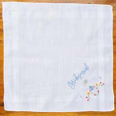 "One of a kind new and unused hand embroidered \"Bridesmaid\" vintage fine white cotton lawn handkerchief. The handkerchief has a machine embroidered posy of gorgeous red, yellow and blue flowers in one corner. The sides of the handkerchief are finished off with a machine edge. I have used 100% colour fast contrasting blue embroidery thread for the \"Bridesmaid\" inscription on this gorgeous handkerchief. This lovely keepsake is finished off with a natural mother of pearl heart shaped button. Th Blue Embroidered Handkerchief For Wedding, Blue Embroidered Handkerchiefs For Wedding, Blue Cotton Embroidered Fabric For Wedding, Blue Embroidered Wedding Handkerchief, Blue Embroidered Cotton Fabric For Wedding, Embroidered Cotton Handkerchiefs For Weddings, Wedding Cotton Handkerchief With Machine Embroidery, Floral Embroidered Cotton Fabric For Wedding, Wedding Floral Embroidered Cotton Fabric