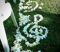 a white bench sitting on top of a lush green field next to flowers in the grass