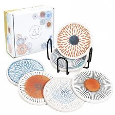 five plates are stacked on each other in front of a box with an orange and blue design