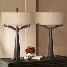 two lamps sitting on top of a table next to a vase with flowers in it