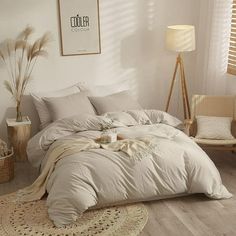 a large bed sitting in a bedroom on top of a wooden floor next to a window