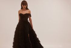 Spectacular frill-layered ball gown in black that will become a timeless wardrobe item. Featuring a one-shoulder heart-shaped neckline, a semi-transparent corset with lace-up closure on the back, and a stunning frill-layered volumetric maxi tulle skirt with a long train. Details: Material: Tulle Fabric Composition: 100% polyester Sleeves style: Sleeveless one-shoulder Silhouette: Princess dress Skirt length from waist: 115 cm Neckline: Heart-shaped neckline Back: Lace-up corset Built-in cups Lin Transparent Corset, Milla Dresses, Maxi Tulle Skirt, Tulle Maxi Skirt, Princess Ball Gowns, Sleeves Style, Timeless Wardrobe, Long Train, Tulle Fabric