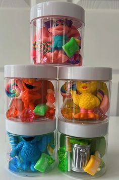 three plastic containers filled with toys on top of a table