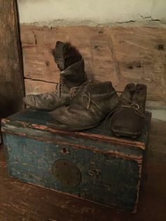 an old pair of shoes sitting on top of a wooden box next to a door