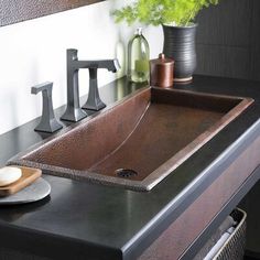 a bathroom sink sitting on top of a counter next to a vase filled with flowers