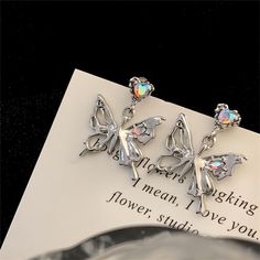 Description: Geometric Dangling Butterfly Earrings Specifications:Size: 27 mm * 22 mmWeight: 7 g/pairMaterial: Copper, Rhinestone, SilverColor: Silver "Flutter into style with these Geometric Dangling Butterfly Earrings! These unique earrings add a touch of whimsy to any outfit while the geometric design adds a modern edge. Get ready to turn heads and spread your wings with these playful accessories. 🦋" Silver Alloy Drop Clip-on Earrings, Trendy Alloy Crystal Earrings, Silver Alloy Crystal Party Earrings, Silver Alloy Crystal Earrings For Party, Silver Rhinestone Alloy Earrings, Silver Alloy Crystal Earrings, Trendy Silver Metal Crystal Earrings, Trendy Silver Crystal Earrings, Elegant Metal Wing-shaped Earrings