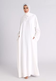 Our premium textured plain white abaya is made from highest quality of polyester and crepe fabric. Extreme care is taken during the manufacturing process to ensure the fit and the stitching quality is at the optimum standard giving you the premium feel where compromise is not an option. The White Textured Abaya features Zip pockets in the seam of the abayas which remains hidden and is perfect for daily and casual wear. Ideal for Hajj, Umrah, Ramadan and daily wear. Also available in various othe Abaya For Hajj, Hajj Outfit For Women, Abaya For Umrah, Hajj Abaya, Umrah Outfit, Dubai Kaftan Dress, Closed Abaya, White Abaya, White Hijab