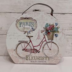 a sign that has a bicycle with flowers on the handlebars and an eiffel tower in the background