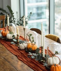 the table is set with candles and pumpkins