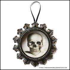 a black and white photo of a skull in a frame with an ornate border around it