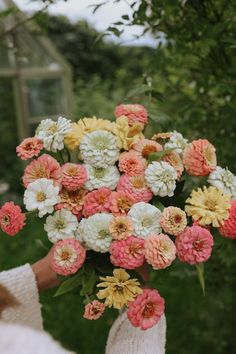 a person holding a bouquet of flowers in their hands