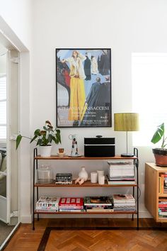 a living room filled with furniture and a poster on the wall above it's bookshelf