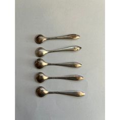 six silver spoons are lined up in a row