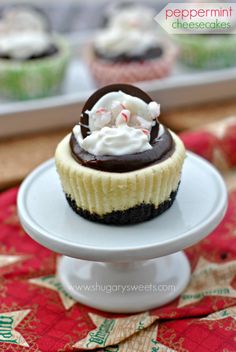 a cupcake with white frosting and peppermint on top sitting on a cake plate