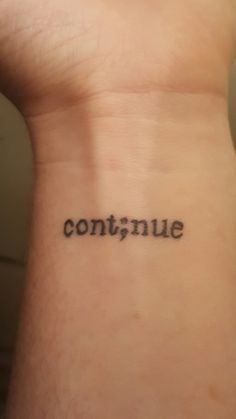 a person with a tattoo on their wrist that says continue