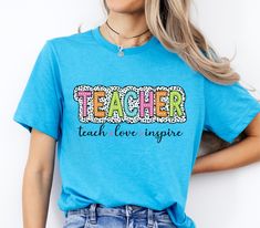 Get ready for a new school year with our Back to School T-shirt, perfect for Pre-K teachers! This charming shirt features a playful design that celebrates the excitement of returning to the classroom. Made from soft, breathable fabric, it ensures all-day comfort, whether you're welcoming students or planning lessons. The vibrant colors and fun graphics make it a standout addition to any teacher's wardrobe, while the easy-care material ensures it's ready for the hustle and bustle of school life. Show your enthusiasm for teaching and inspire your little learners with this delightful and practical back-to-school tee, a must-have for every dedicated Pre-K teacher. Pre K Teacher, Fun Graphics, Teacher Wardrobe, Teacher Back To School, New Teacher, School Tees, Gift Cute, New Teachers, New School Year