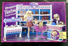 a barbie doll is standing in front of a toy store with two dolls on the counter