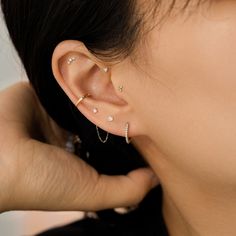 a close up of a person's ear with two piercings on it and one behind the ear