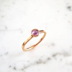 A sweet pink rose cut sapphire in a timeless bezel with a flat 14k rose gold flat band. An everyday piece, in addition to, stacking with other rings for a unique, bold look. genuine pink Sapphire Magenta/Pink Sapphire - Rose Cut faceted sapphire 4 mm round Flat Band Recycled 14 k Rose Gold Ready to ship in Size 7 - Sizable, please message us for a quote. :: please message us for any specifications, time frames, and or change of address. This ring can also be hammered and/or have a matte finish. Pink Gold Sapphire Ring With Round Pink Sapphire, Rose Gold Sapphire Ring With Rose Cut Diamonds, Pink Sapphire Stackable Ring Gift, Stackable Ruby Ring In 14k Rose Gold, Rose Gold Stackable Rings With Bezel Setting, Rose Gold Birthstone Ring With Rose Cut Diamonds, Pink Gold Round Sapphire Ring Gift, Fine Jewelry Pink Ring With Bezel Setting, Everyday Rose Gold Stackable Rings With Bezel Setting