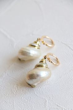 Natural sea shell gold hoop earrings in 18k gold plated.  Earrings hoop size: 12mm dia  Shell size: about 25-30mm Metal component: 18k gold plated brass base This listing is for a pair of earrings. ﹎﹎﹎﹎﹎﹎﹎﹎﹎﹎﹎﹎﹎﹎﹎﹎﹎﹎﹎﹎﹎﹎ ▲ Care instruction:  Please remove it before bathing or swimming.  Avoid your jewelry touching chemical such as hairsprays or perfumes.  Using soft cloth to clean your jewelry every time after wearing it, and store it in a dry and cool place. ▲ Gift packaging:  All products will Gold Small Hoop Jewelry For The Beach, Gold Small Hoop Earrings For The Beach, Yellow Gold Pierced Earrings For Beach, Yellow Gold Beach Earrings, Single Shell-shaped Gold Earring, Elegant Small Hoop Earrings For Beach, Gold Mother Of Pearl Shell, Gold Dangle Shell Earrings With Pearl Drop, Gold Shell With Matching Earrings